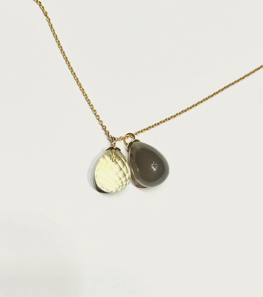 Atelier Beatrix Wolter, Anhänger facettierter Citrin-Tropfen mit einer 750 Gold Anängeröse an eier Kette aus 750 Gold. Daneben ein Anhänger aus grauem Mondstein mit einer 750 Gold Anhänger-Kappe und Öse